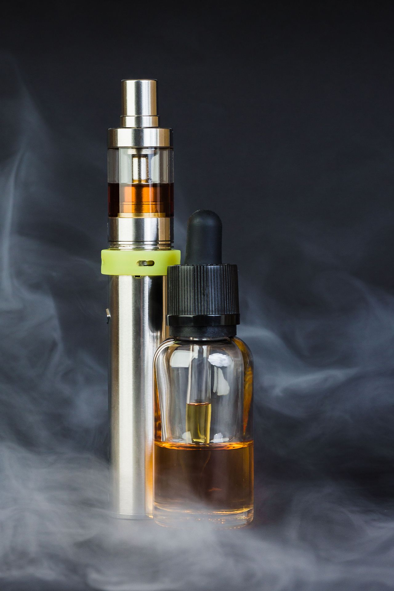 Vape pen and e-liquid bottle with vapor against a dark background