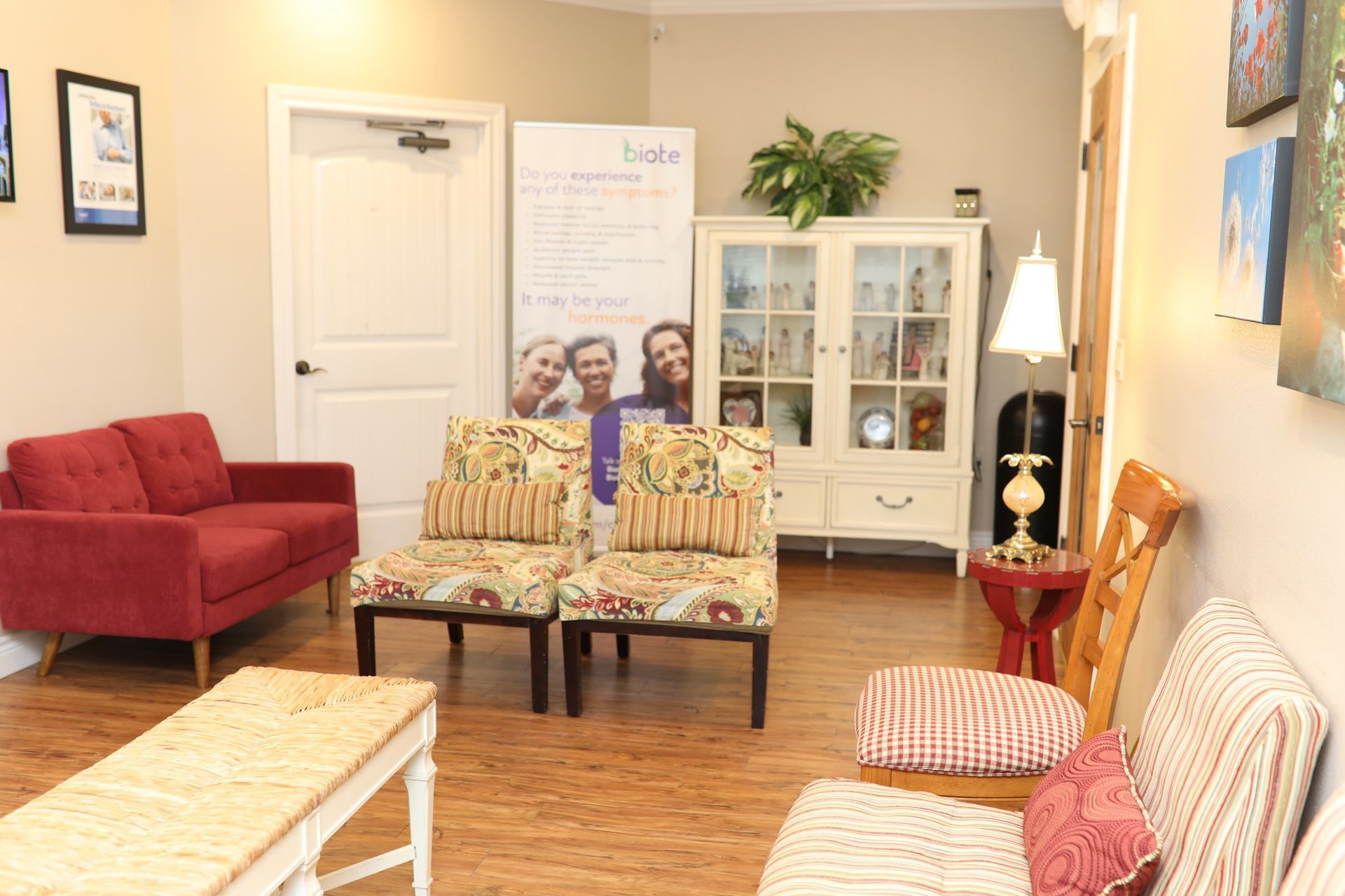 A waiting room with a couch, chairs , and a table.