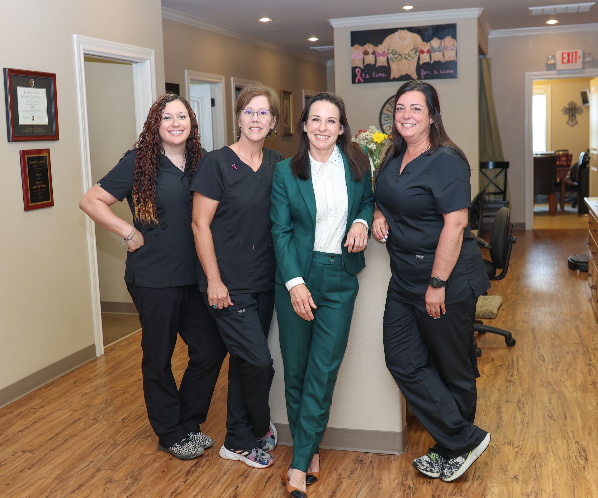 A group of women are posing for a picture in a dental office.