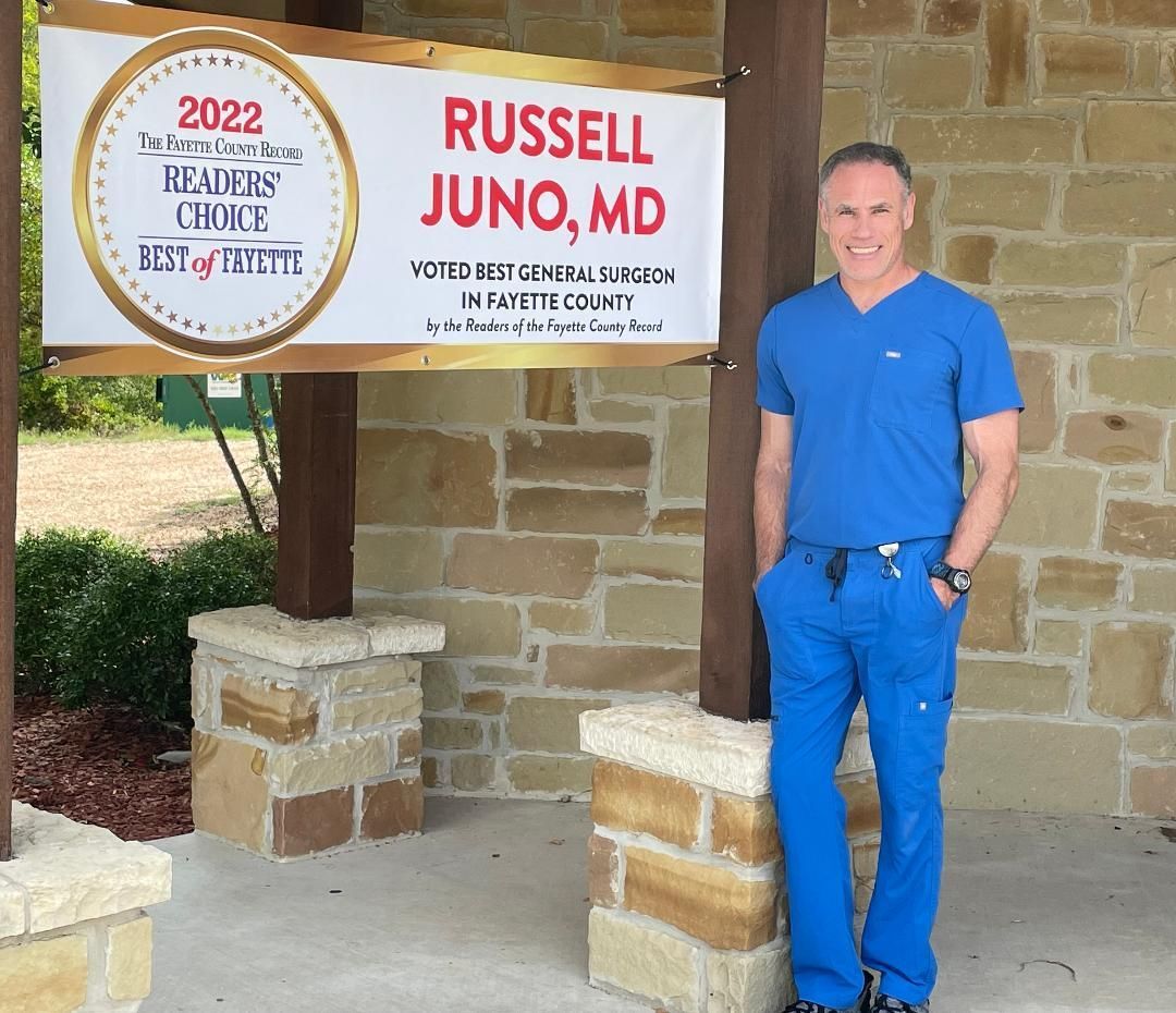 A man standing in front of a sign that says russell juno md
