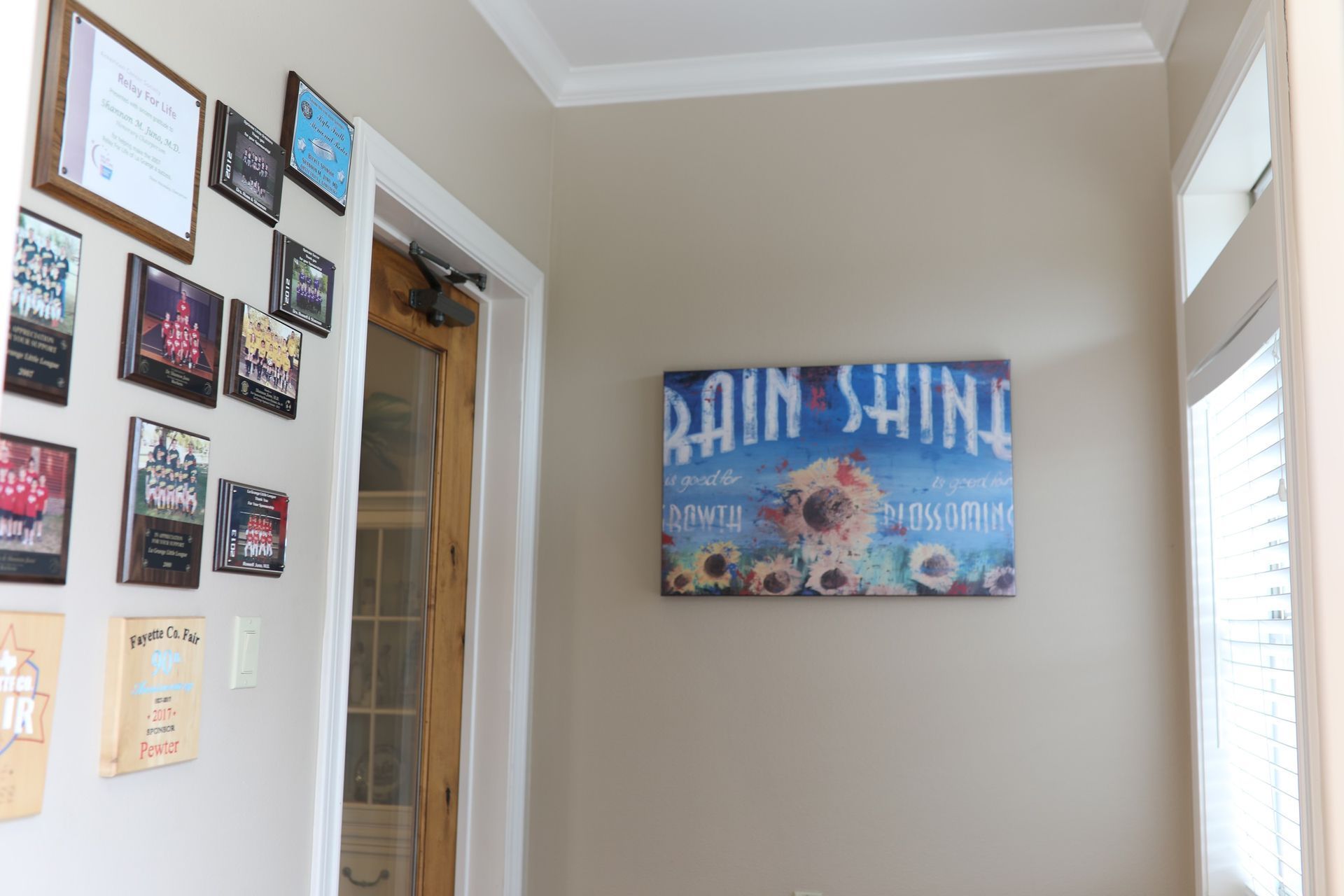 A hallway with a painting on the wall that says rain shine