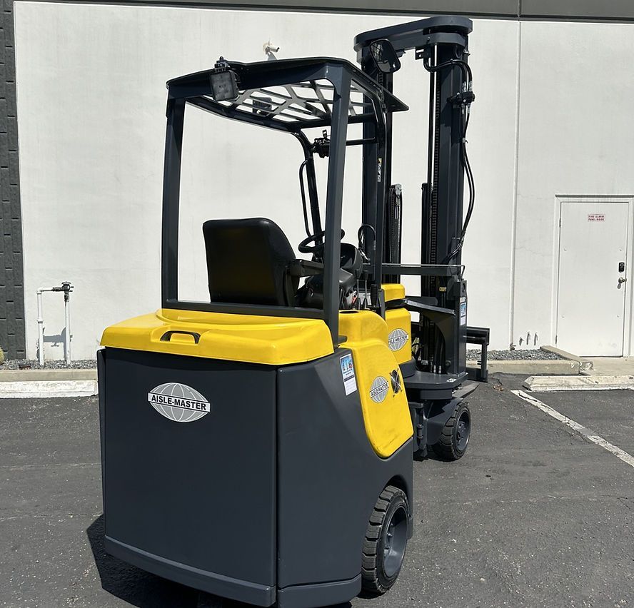 A yellow and black forklift is parked in front of a building.