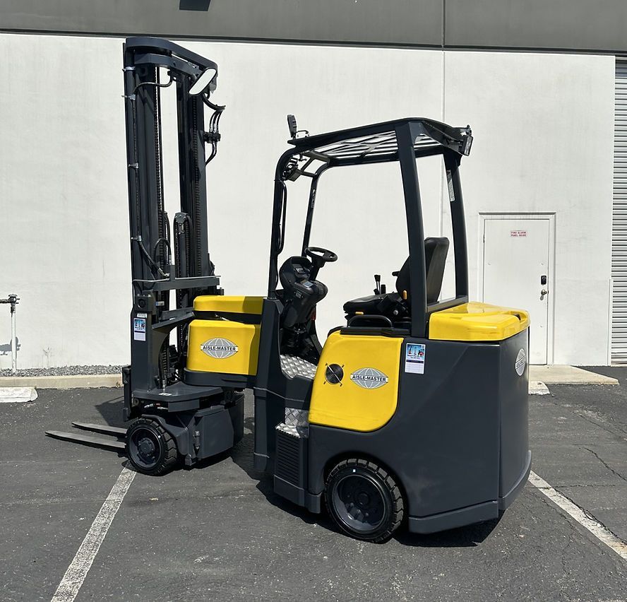 Two forklifts are parked in a parking lot in front of a building.