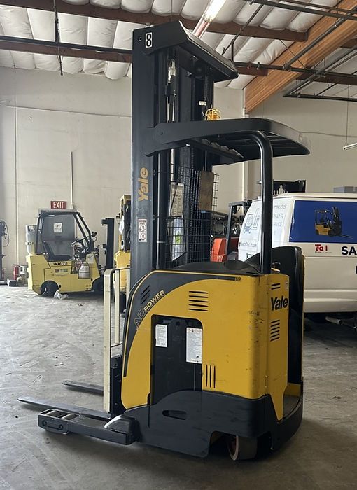 A yellow and black forklift is parked in a warehouse.