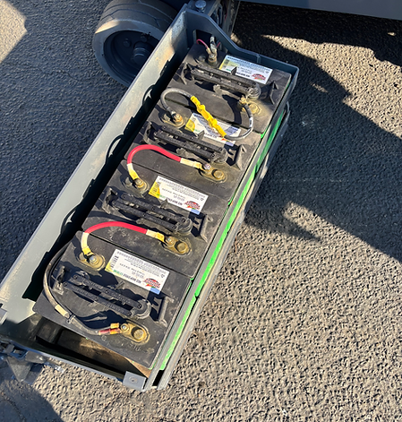 A bunch of batteries are stacked on top of each other on the ground.