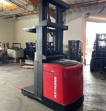 A red raymond forklift is parked in a warehouse.
