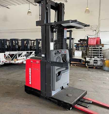 A red and black forklift is parked in a warehouse.