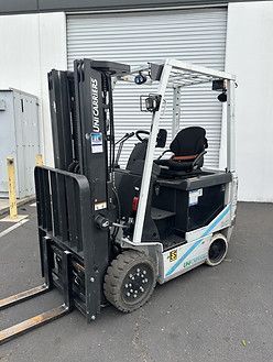 A forklift is parked in front of a building.