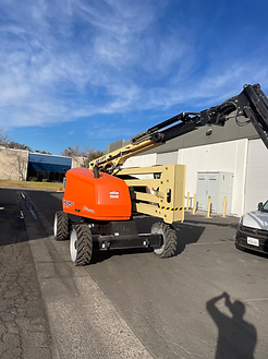 A crane is parked on the side of the road in front of a building.