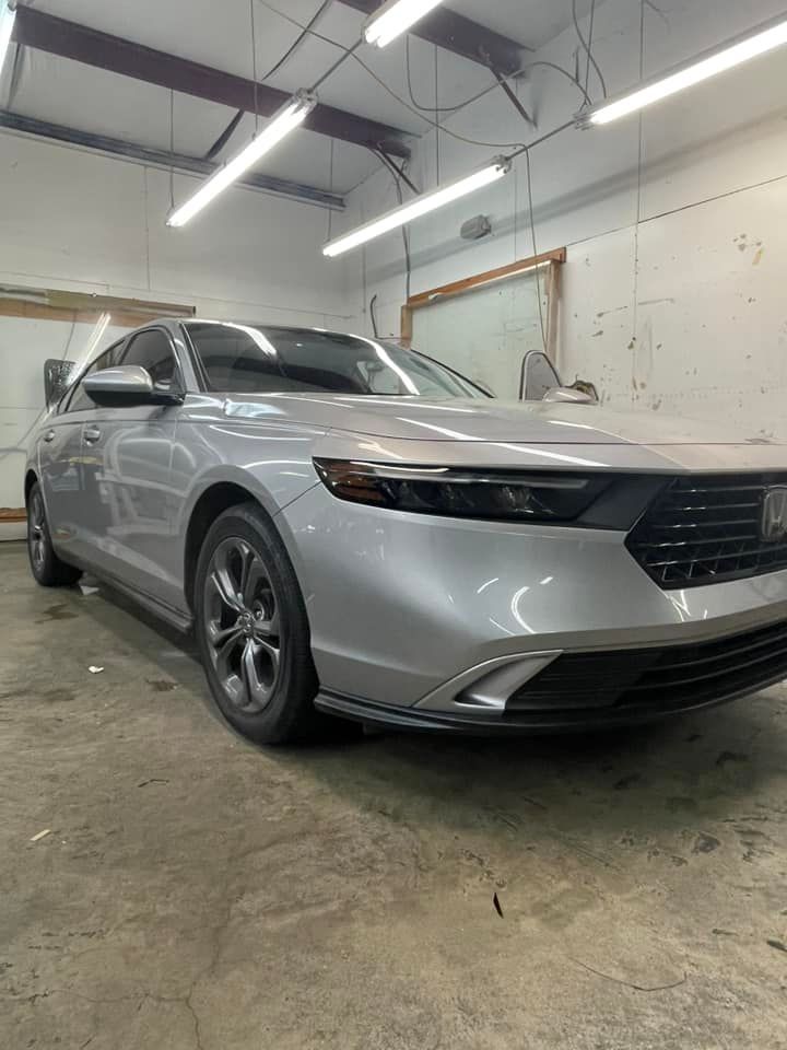A silver Honda Accord parked in a brightly lit automotive workshop.