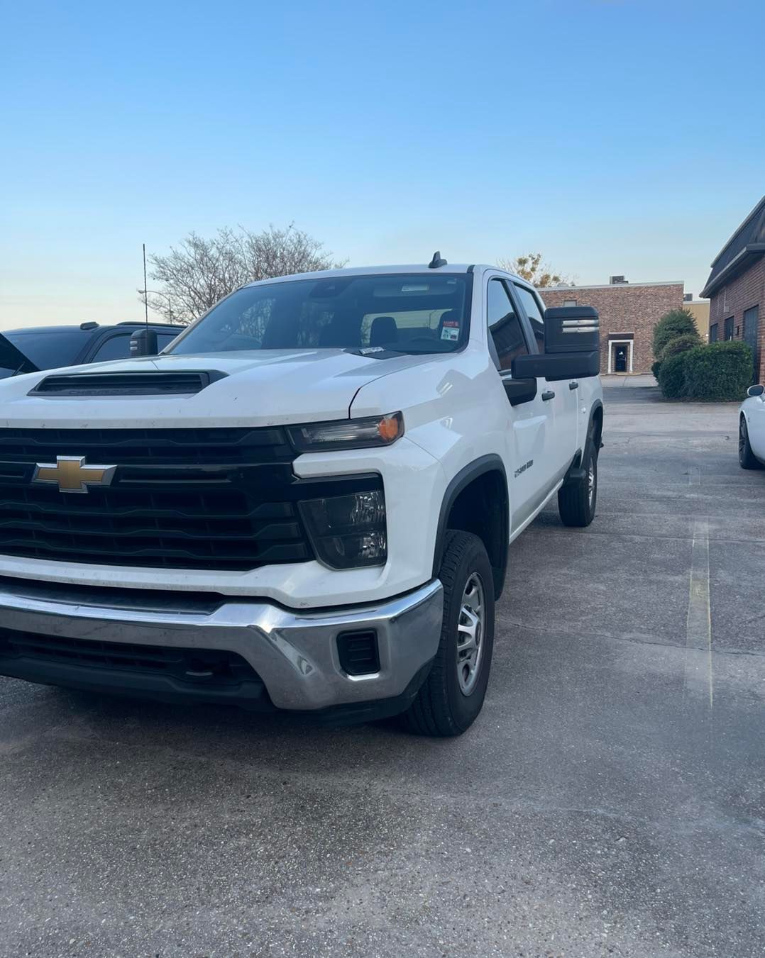 A white Chevrolet Silverado pickup truck parked in an outdoor lot on a sunny day.