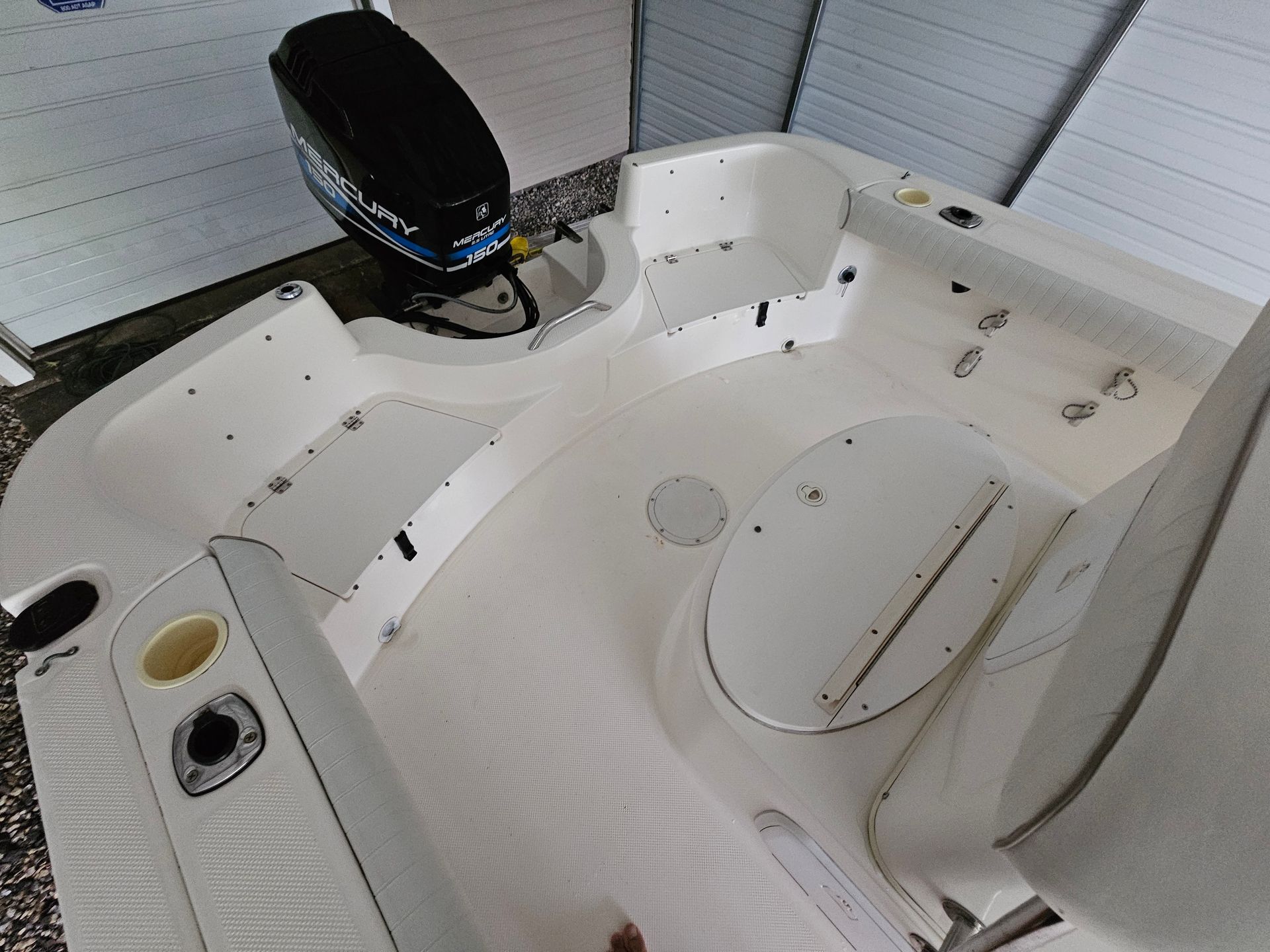 White boat interior with engine, seats, and storage compartments.