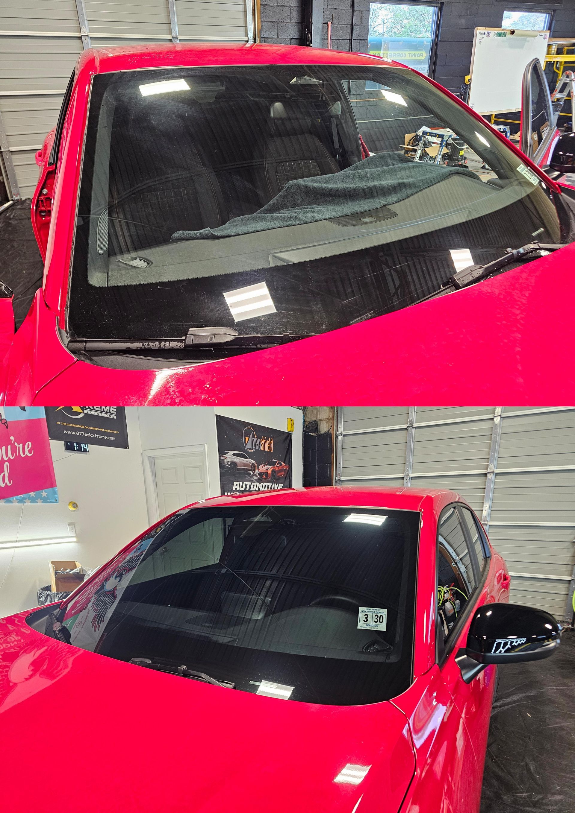 Red car with windshield damage, possibly in a repair shop.