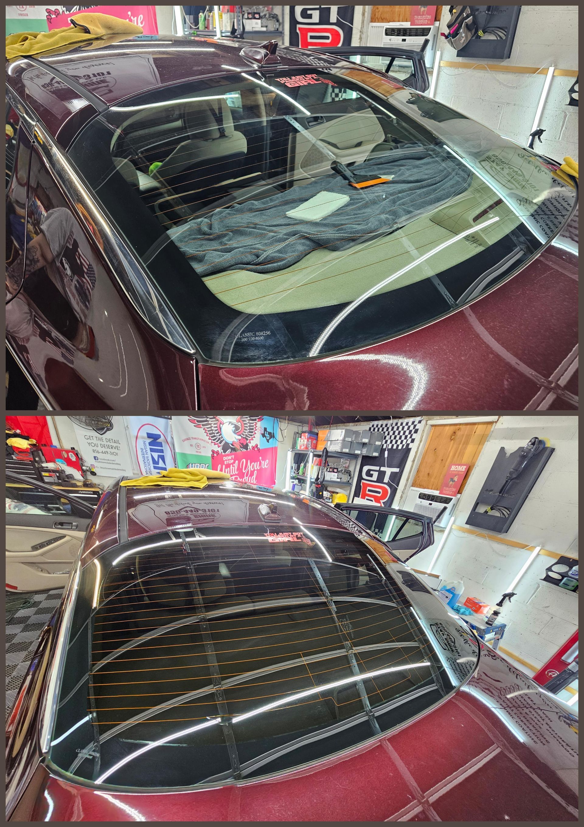 Car's rear window with tinting applied, showcasing a glossy, dark finish.