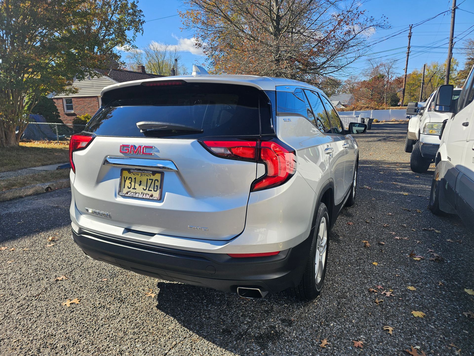 Silver GMC Terrain SUV parked on gravel with a New Jersey license plate.