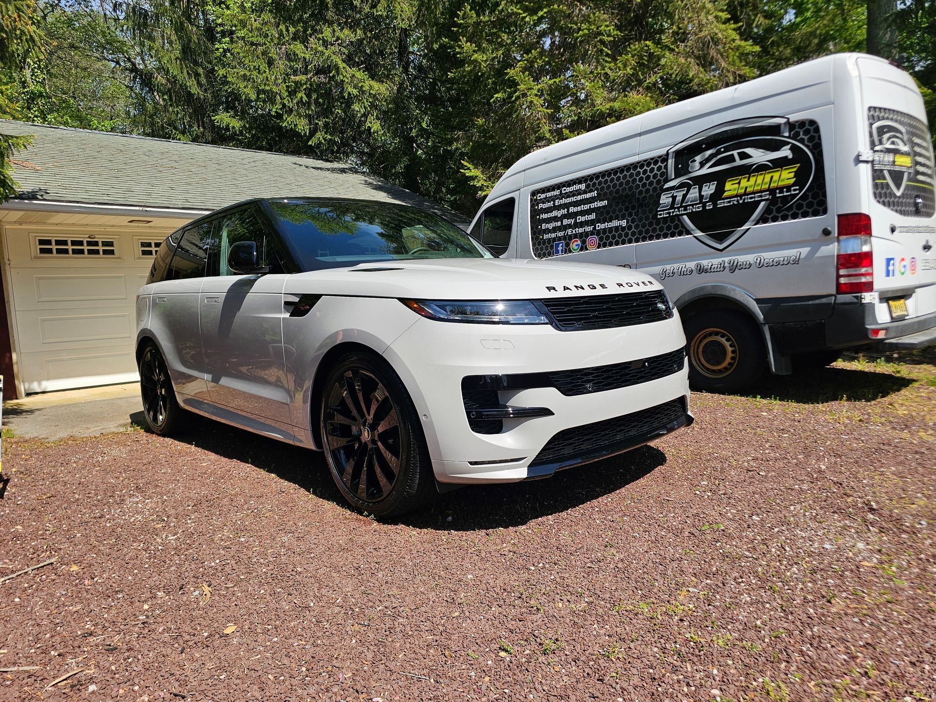 White Range Rover SUV parked in front of a house next to a branded service van.