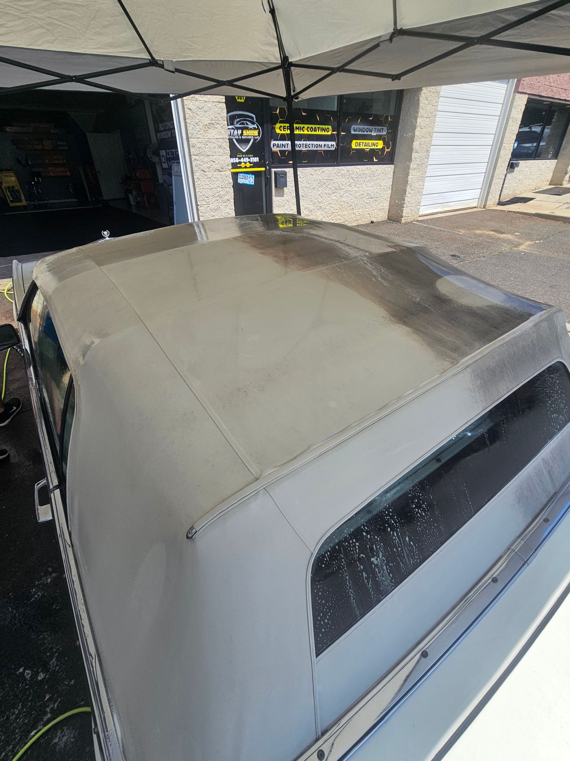 White truck roof with dark staining, under a canopy. Exterior shot.