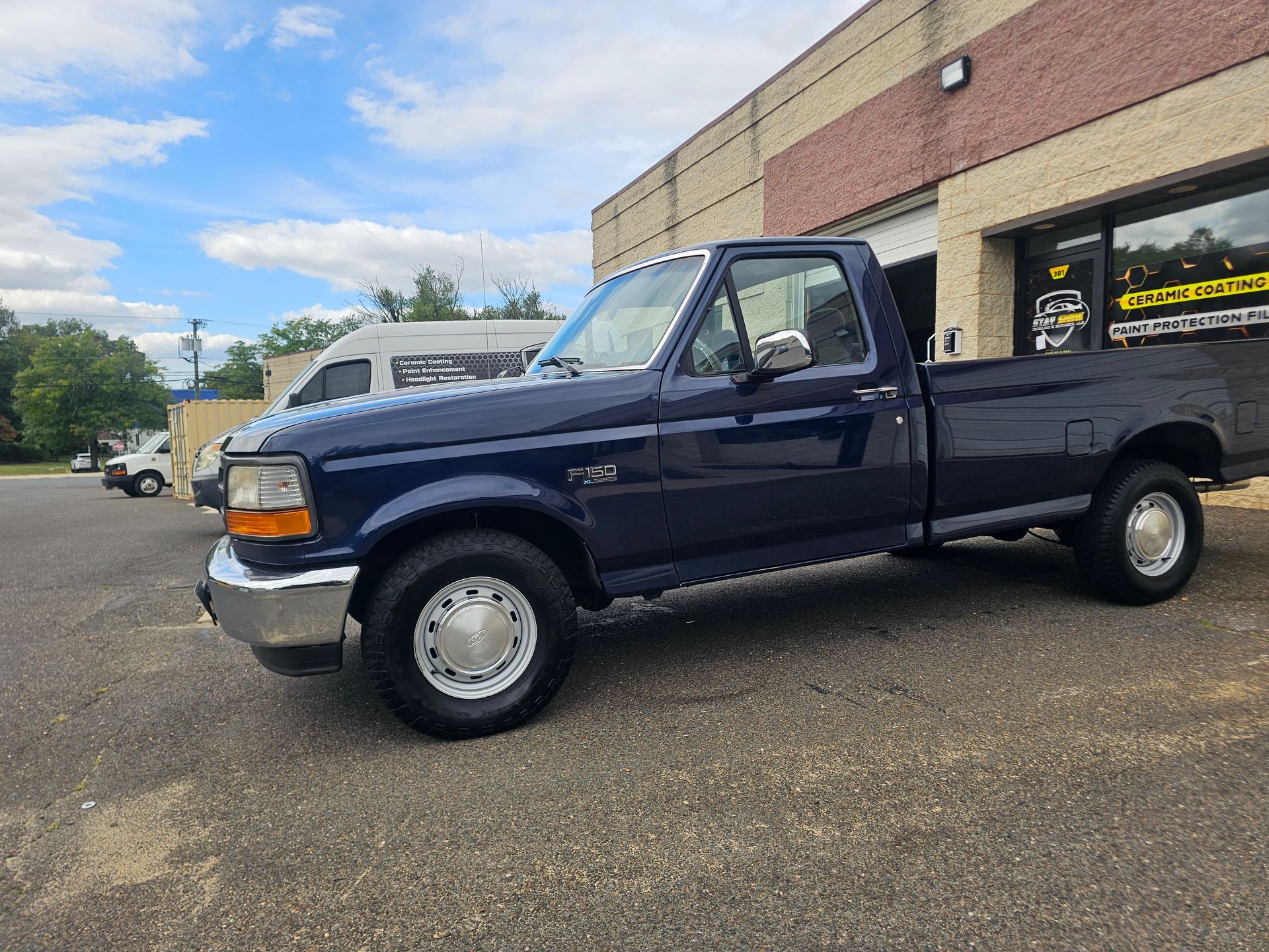 Dark blue Ford pickup truck parked outside a building.