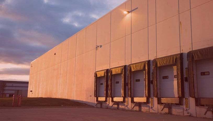 Loading docks on a warehouse building, lit by warm sunset colors.