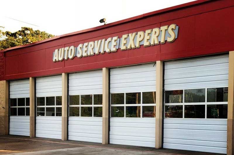 Auto service garage with closed white doors, "Auto Service Experts" sign.