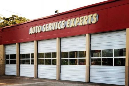 Auto service garage with closed white doors, "Auto Service Experts" sign.