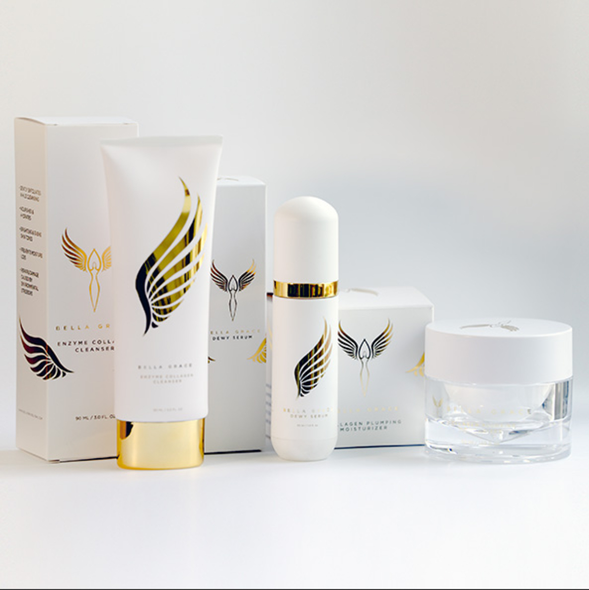 White cosmetic products with gold accents and a winged logo.