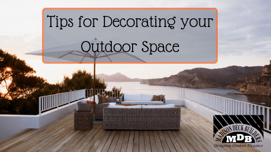 Outdoor deck with furniture and umbrella, overlooking water, text reads 