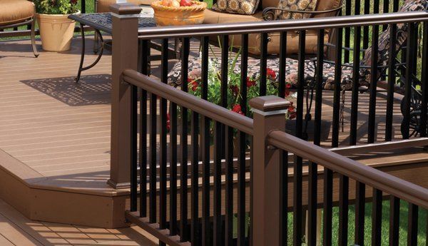 Brown composite deck railing with black vertical bars.