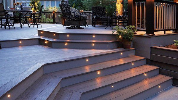 Outdoor deck with steps and embedded lights, seating, and railings.