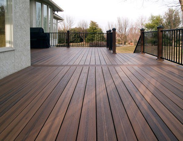 Wooden deck with black railings and a dark brown hue.