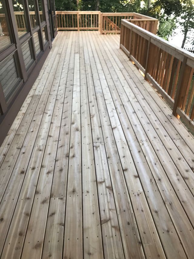 Wooden deck with railing. Light brown wood planks extend outward.