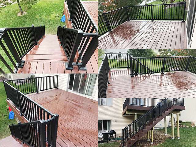 Brown deck with black railing and stairs, wet from rain, in a backyard setting.