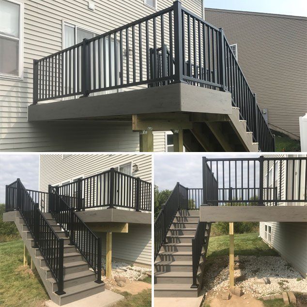Composite deck and stairs with black railing, attached to a house with beige siding.