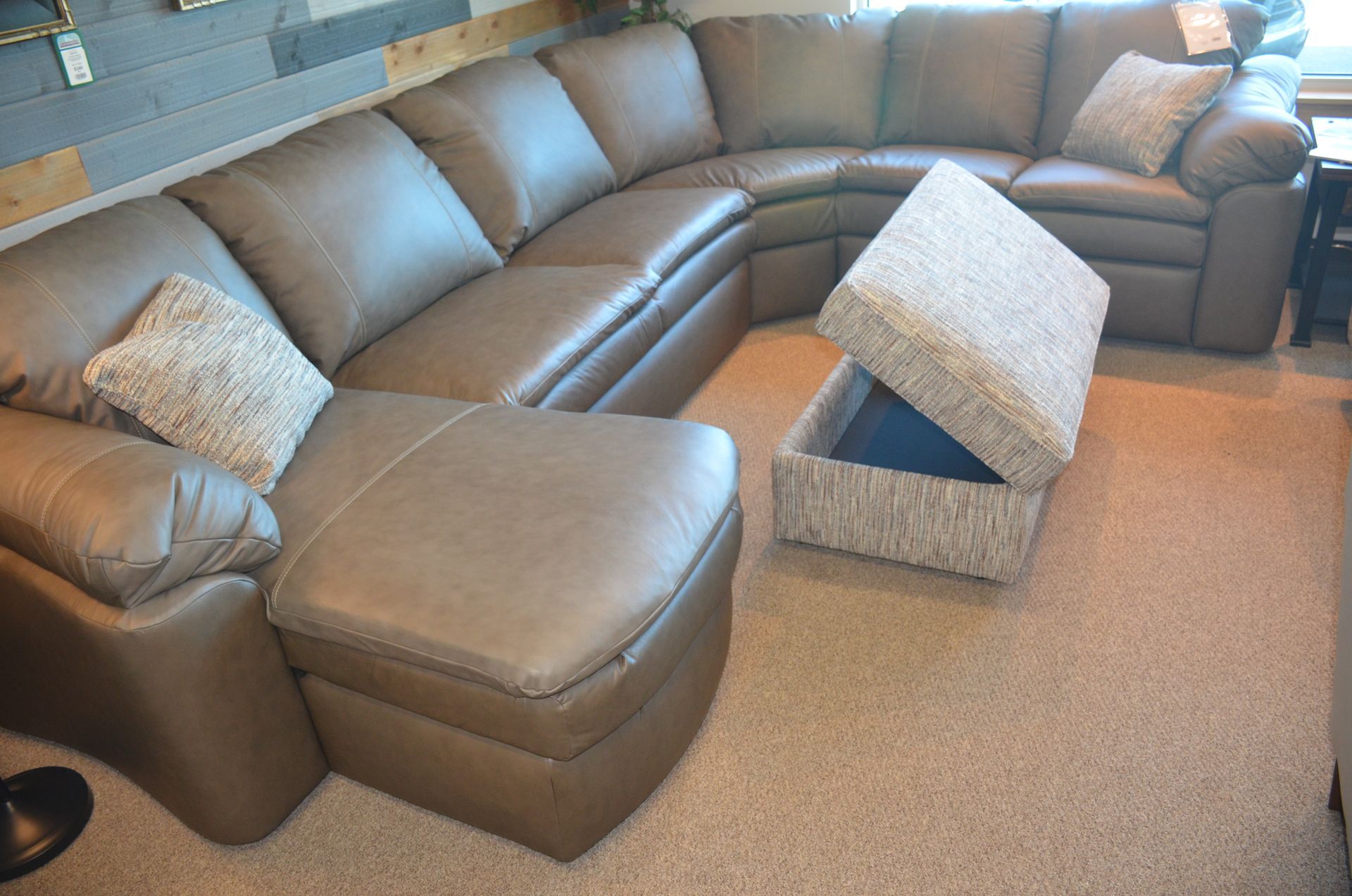 A living room with a sectional couch, ottoman, and coffee table.