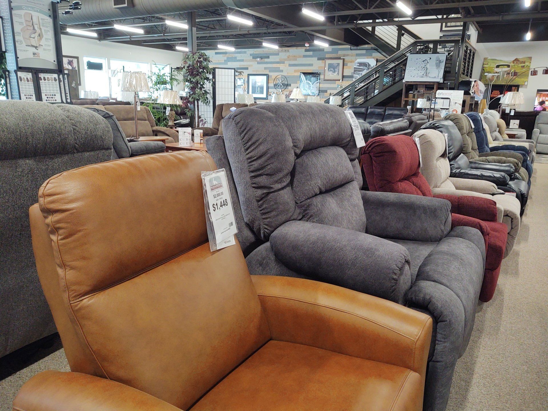 A row of recliner chairs are lined up in a furniture store.