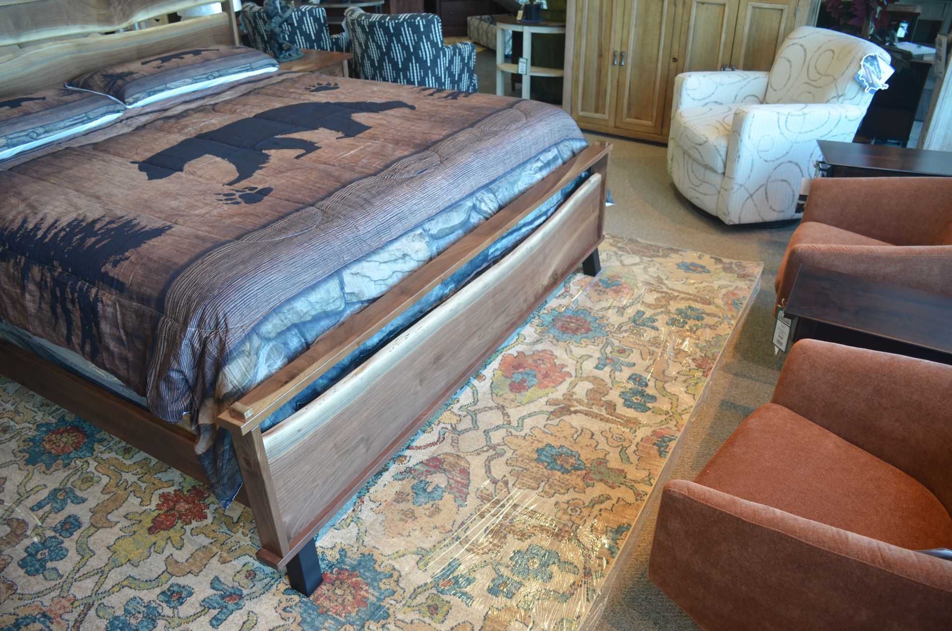 A bedroom with a bed, chairs and a rug