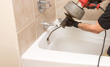 A man is cleaning a bathtub with a machine