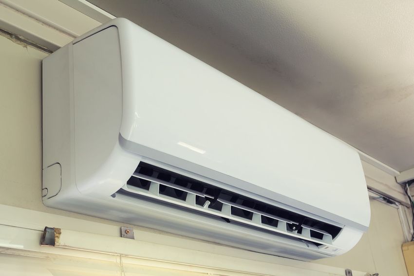 White wall-mounted air conditioner unit, mounted indoors.