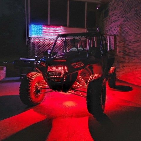 A red ATV is parked in front of an American Flag
