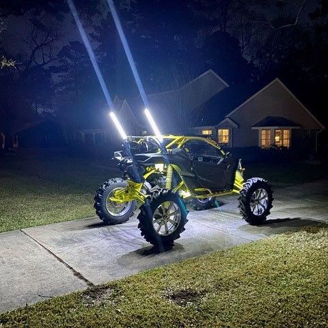 A yellow ATV is parked on the sidewalk in front of a house at night