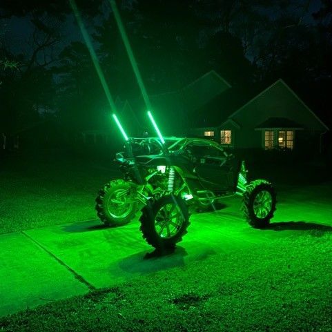A ATV with green lights is parked in a driveway at night