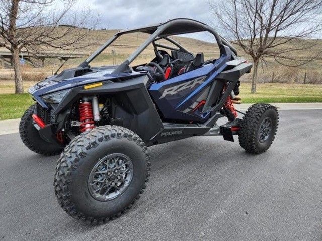 A blue and black atv is parked on the side of the road.