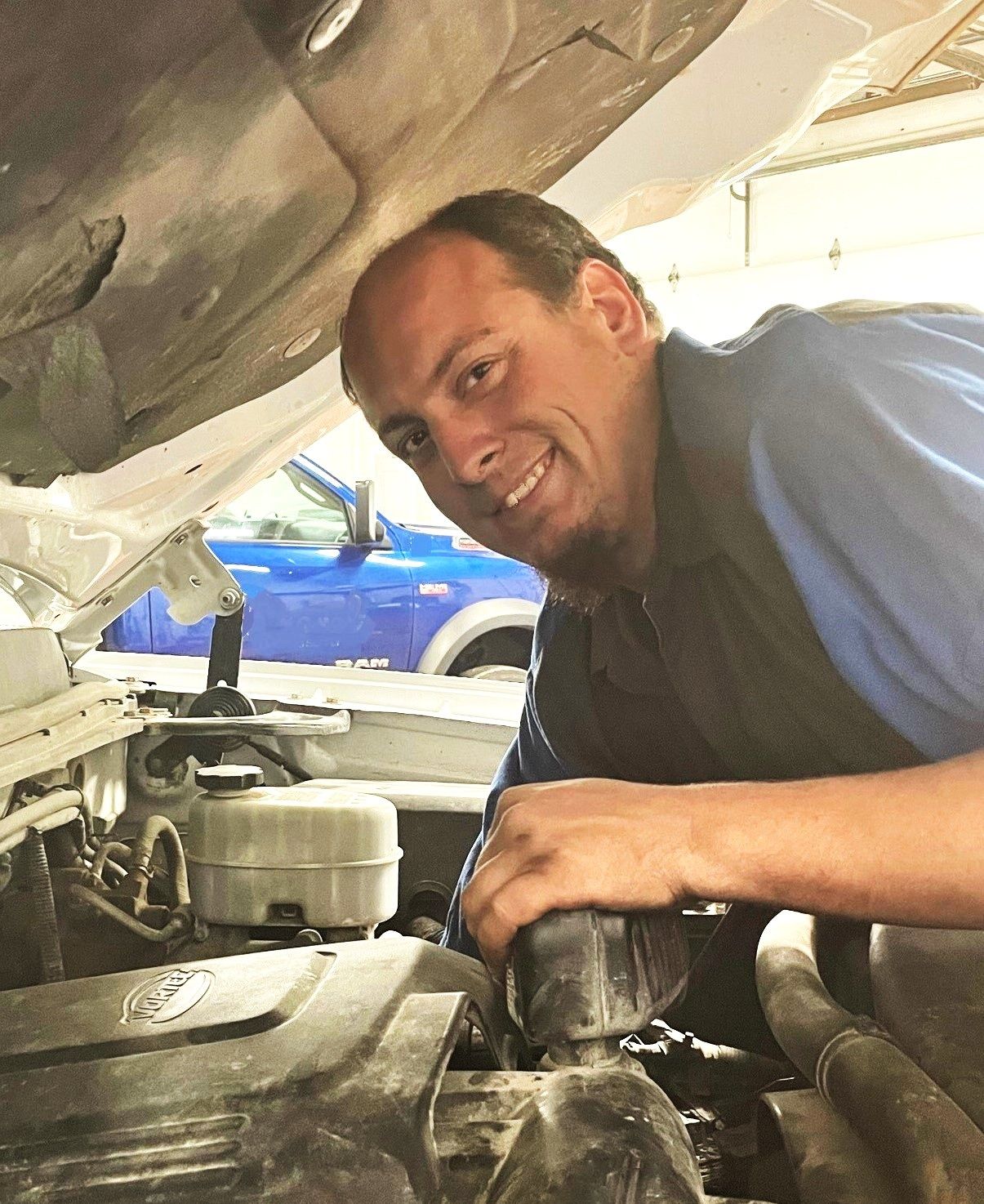 A man is working under the hood of a car