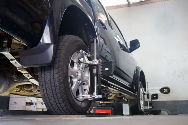 A truck is being aligned in a garage with a machine.