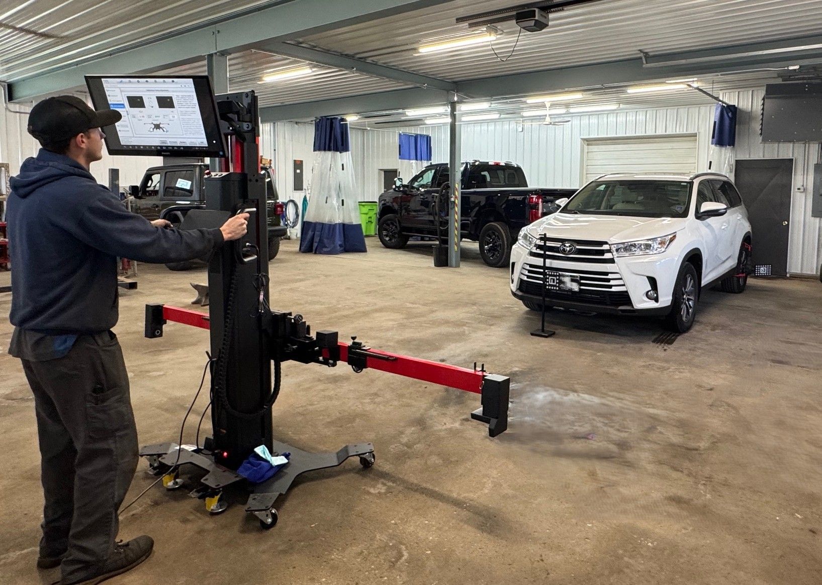 A man is standing next to a machine in a garage.