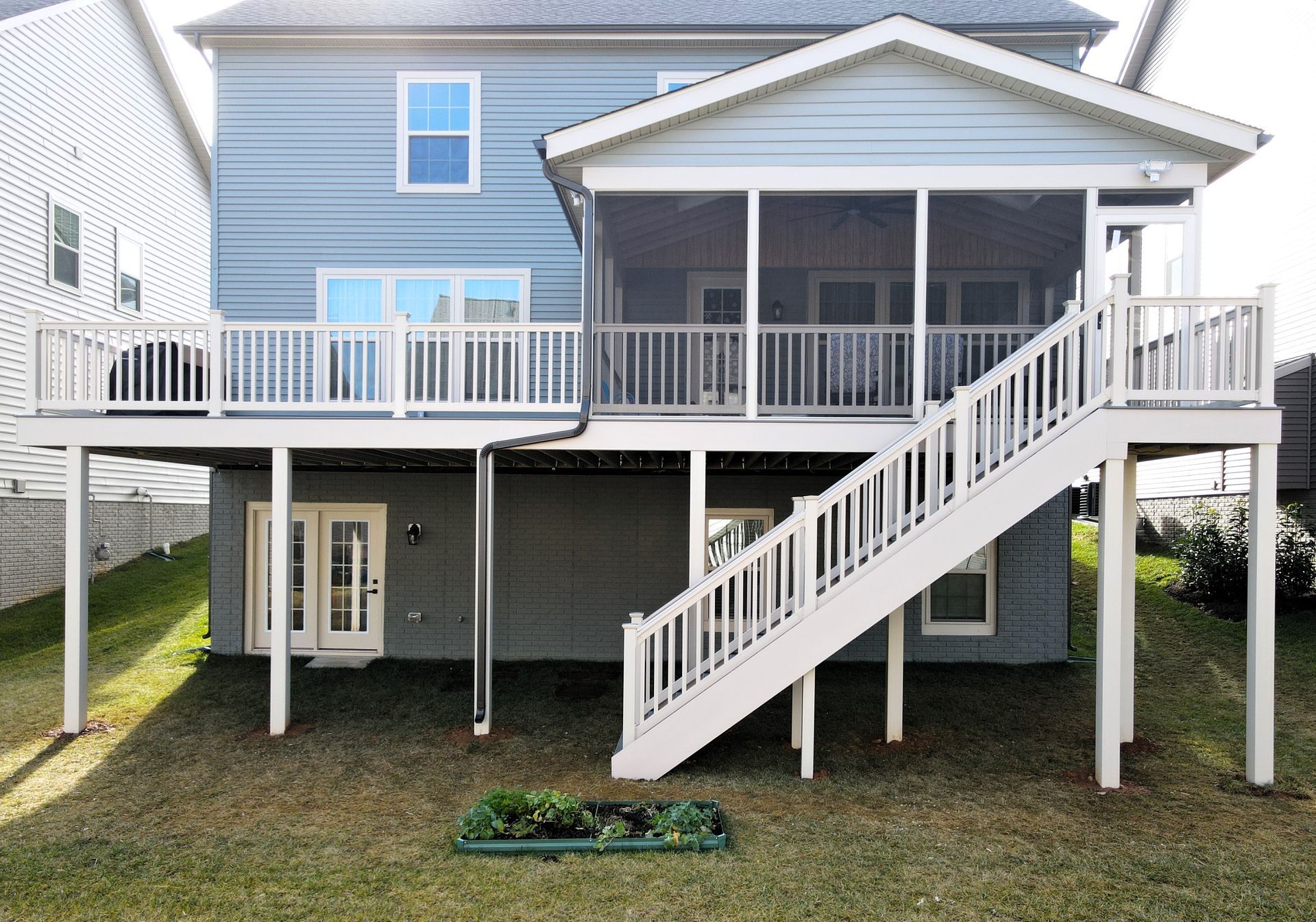 the back of a house with a screened in porch and stairs .