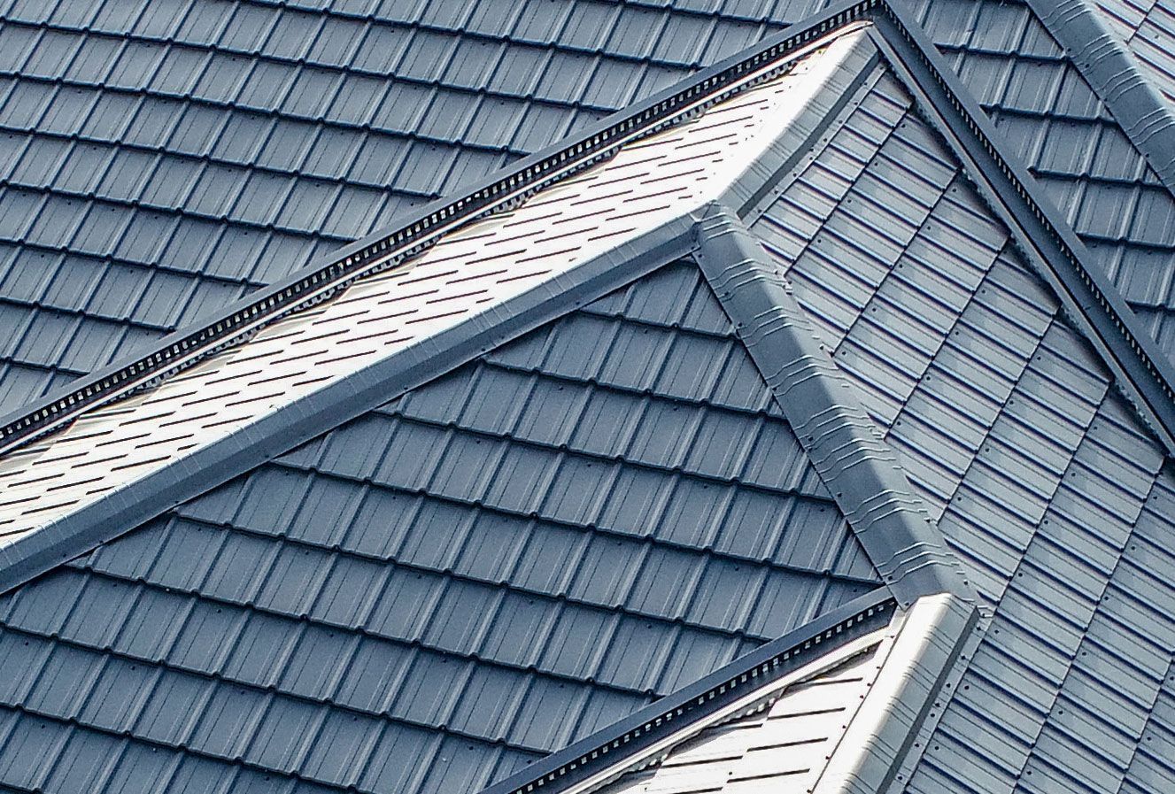 Blue-gray tiled roof with intersecting ridgelines and white trim details