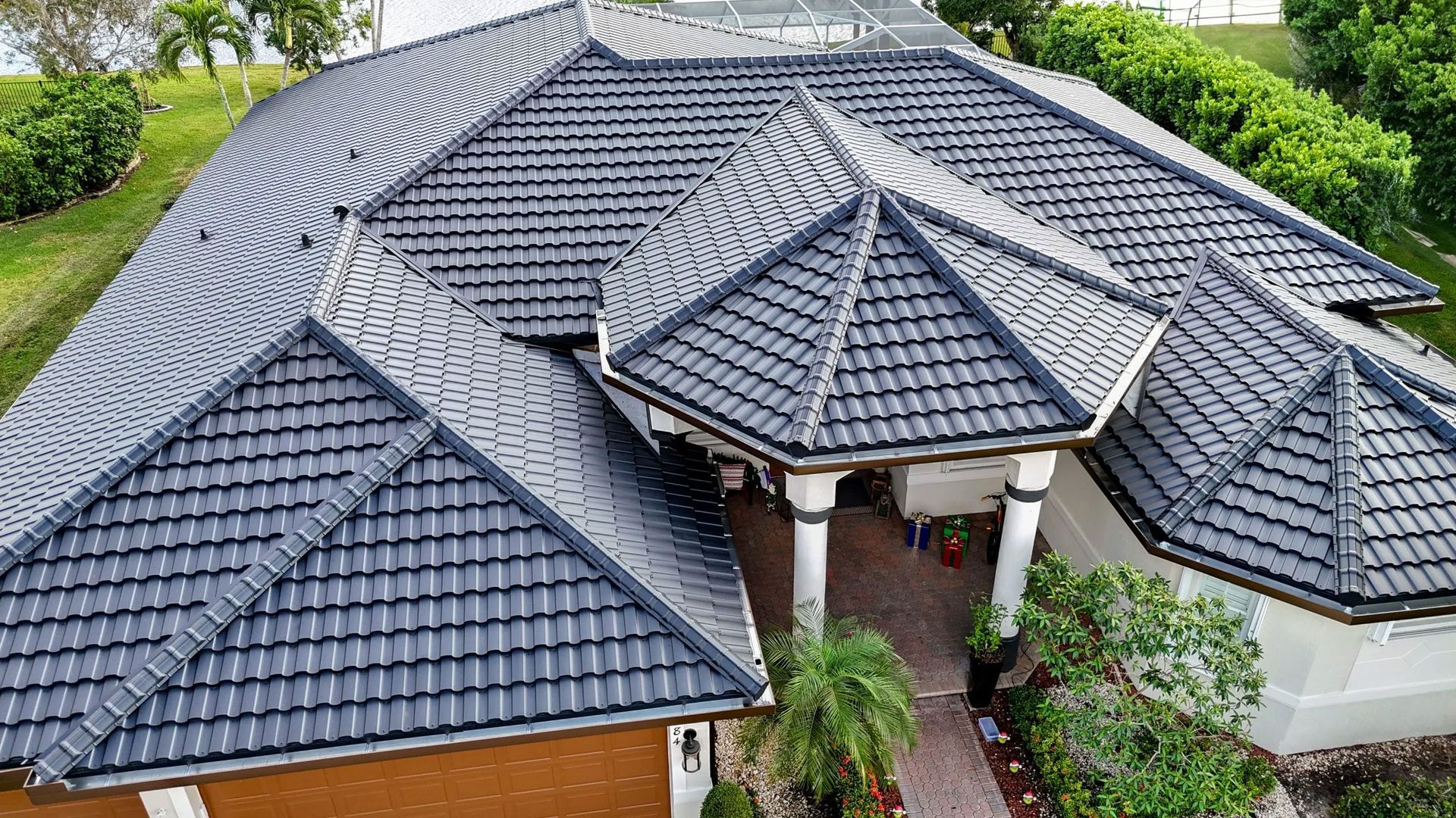 Aerial view of a house with a dark gray tiled roof and central entrance courtyard.