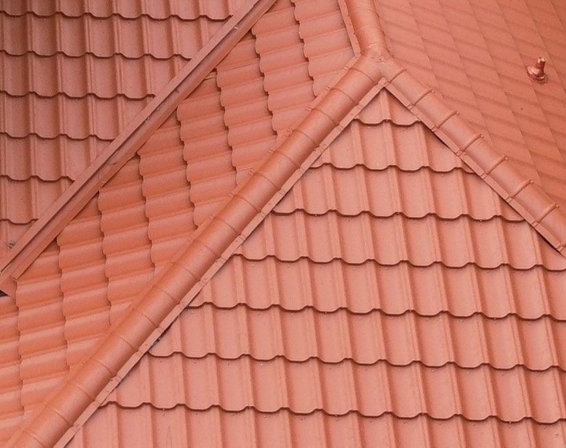 Terracotta roof tiles with intersecting ridgelines and a dormer window