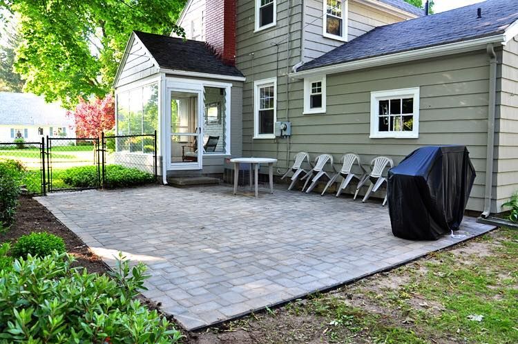A patio with a table and chairs in front of a house.